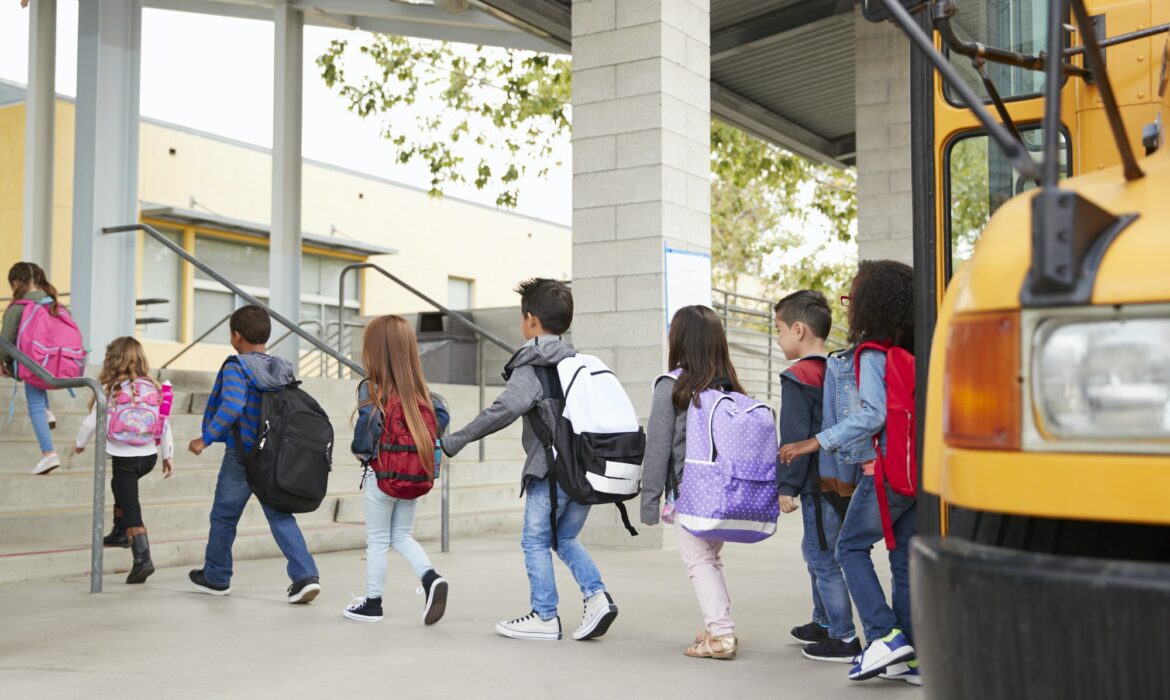 Elementary school kids arrive at school from the school bus